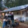Two happy solar customers hugging owner of Sunbridge Solar, Jordan Weisman